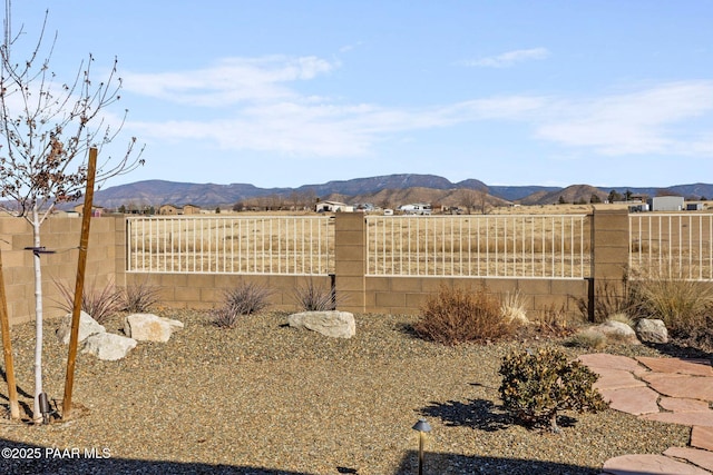 view of yard featuring fence and a mountain view