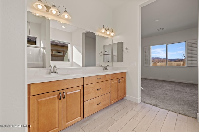 bathroom featuring double vanity, baseboards, visible vents, wood finished floors, and a sink