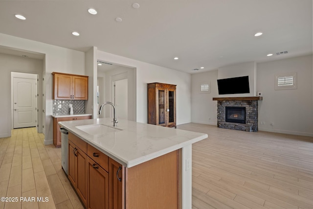 kitchen with stainless steel dishwasher, visible vents, light wood-style floors, and a sink