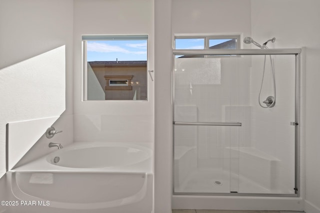 full bathroom featuring a garden tub and a shower stall