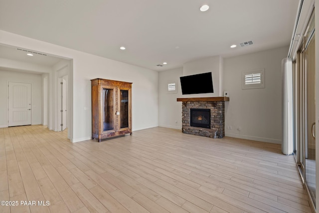 unfurnished living room with recessed lighting, a fireplace, visible vents, baseboards, and light wood-type flooring