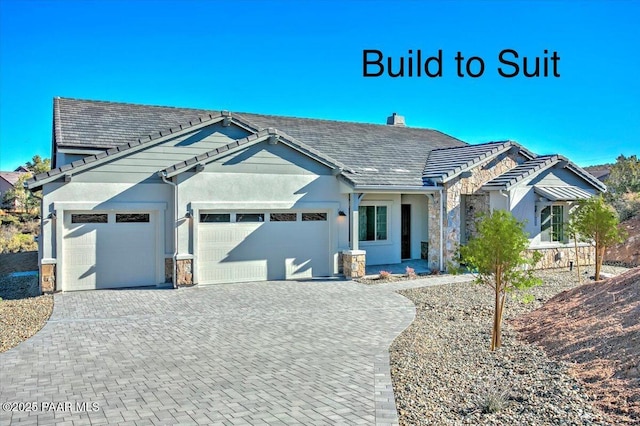 12312 N Otto Cir, Prescott, AZ 86305 - view of front facade featuring stone siding, a tiled roof, decorative driveway, an attached garage, and stucco siding