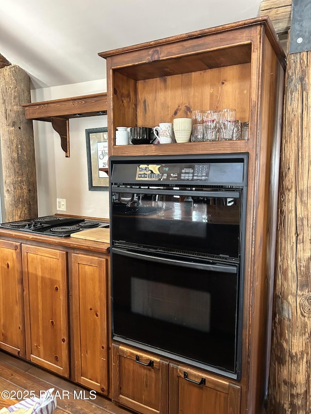 kitchen featuring stovetop, dark hardwood / wood-style flooring, and double oven