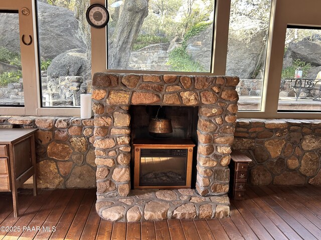 details featuring a stone fireplace and wood-type flooring