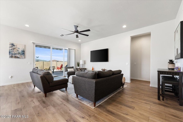 living room with ceiling fan and light hardwood / wood-style flooring