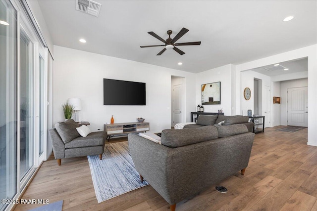 living room featuring ceiling fan and light hardwood / wood-style floors