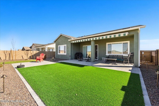 rear view of house featuring a patio area and a lawn