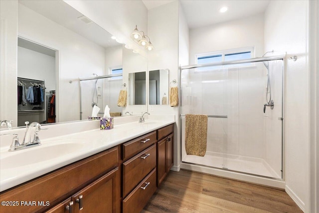 bathroom featuring wood-type flooring, vanity, and a shower with shower door