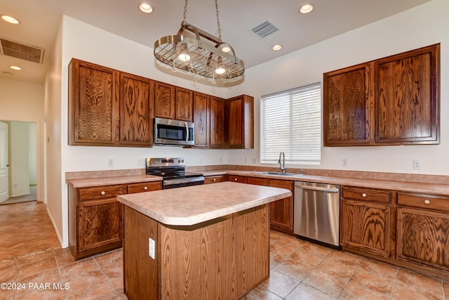 kitchen with a center island, sink, stainless steel appliances, and hanging light fixtures