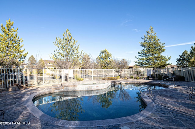 view of swimming pool featuring a patio area and a jacuzzi