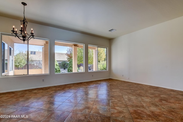 tiled empty room with a chandelier