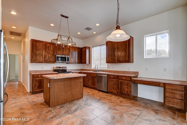 kitchen with decorative light fixtures, a center island, sink, and stainless steel appliances