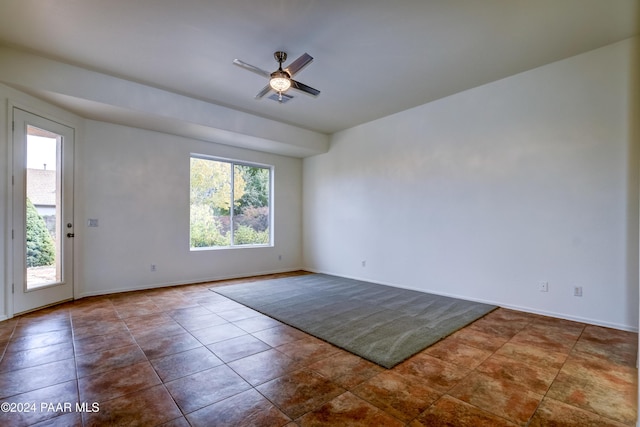 tiled empty room featuring ceiling fan