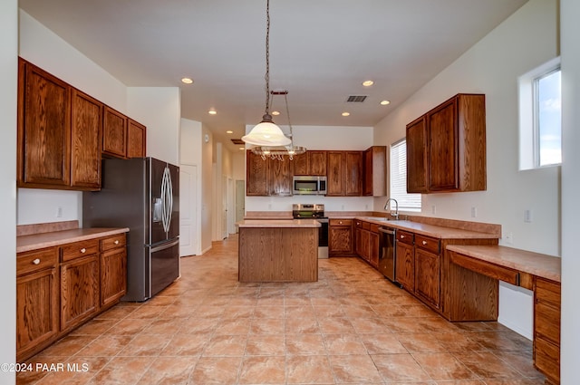 kitchen with appliances with stainless steel finishes, a center island, decorative light fixtures, and sink