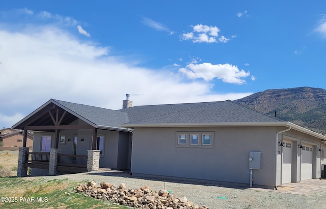 14320 E Casa Serena Way, Prescott Valley, AZ 86315 - view of front of house featuring stucco siding, a porch, a chimney, a mountain view, and an attached garage