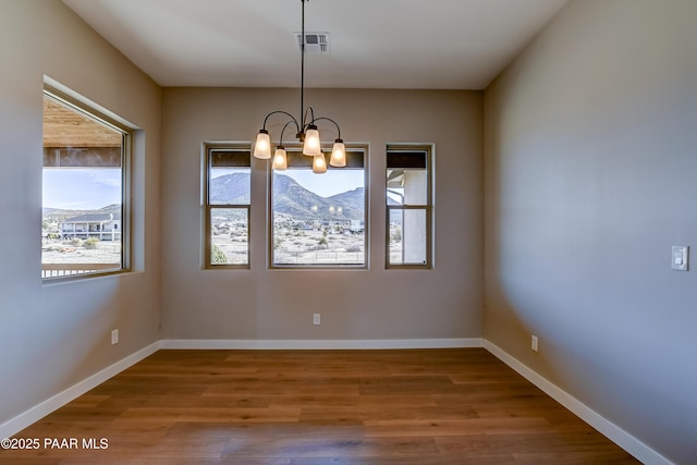 14320 E Casa Serena Way, Prescott Valley, AZ 86315 - unfurnished room with wood finished floors, a chandelier, baseboards, and a mountain view