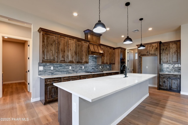 14320 E Casa Serena Way, Prescott Valley, AZ 86315 - kitchen with backsplash, custom range hood, light wood-style flooring, light countertops, and recessed lighting