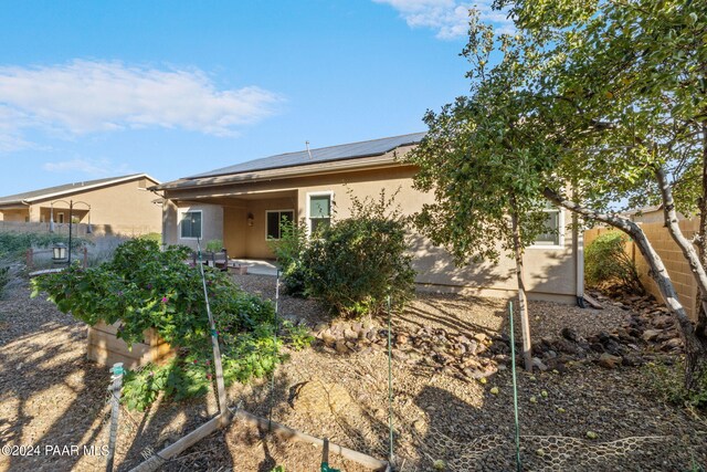 view of front of home featuring a patio and solar panels