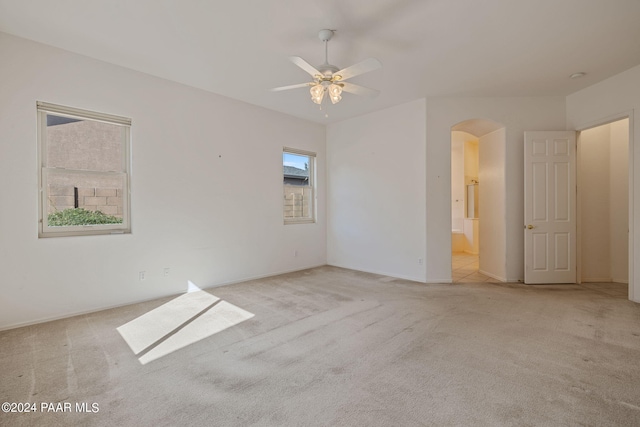 spare room featuring light carpet and ceiling fan