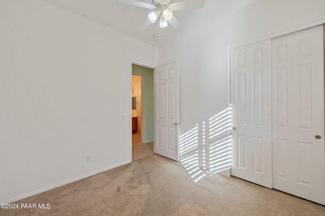 unfurnished bedroom with ceiling fan, a closet, and light colored carpet