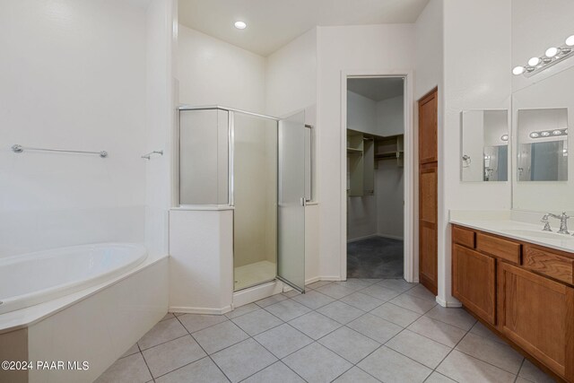 bathroom featuring tile patterned flooring, vanity, and shower with separate bathtub