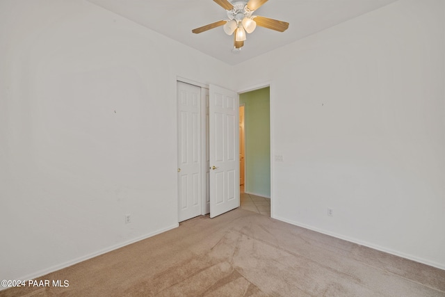 carpeted spare room featuring ceiling fan