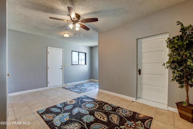 tiled foyer with ceiling fan and a textured ceiling