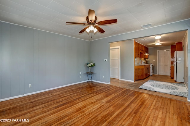 unfurnished living room with ceiling fan and light wood-type flooring