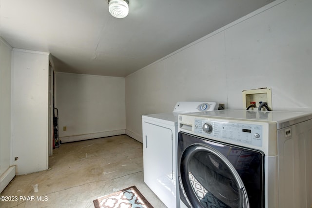 clothes washing area with a baseboard radiator and washer and dryer