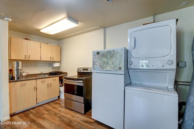 kitchen featuring stacked washer and clothes dryer, sink, white fridge, stainless steel electric stove, and light hardwood / wood-style floors