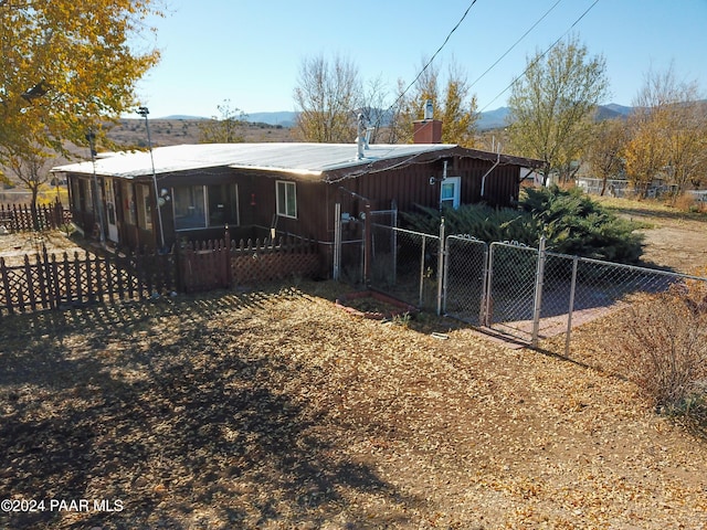 12995 E Main St, Dewey-Humboldt, AZ 86329 - rear view of property with a fenced front yard, a chimney, a mountain view, and a gate