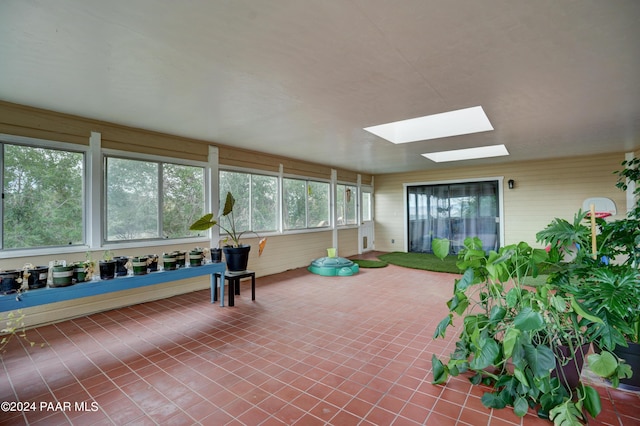 unfurnished sunroom with a skylight