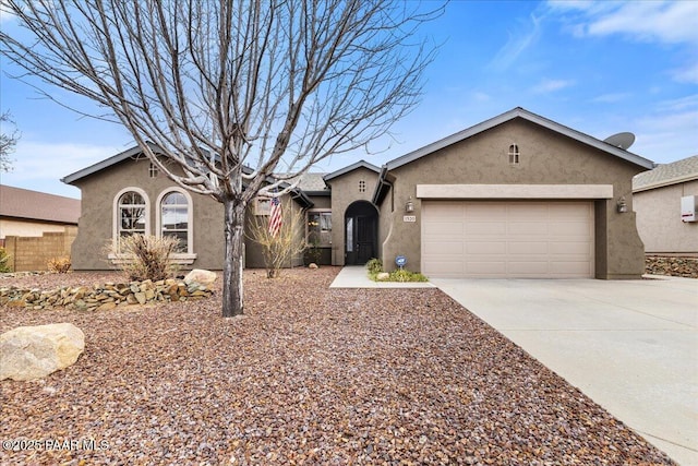 view of front of property featuring stucco siding, a garage, concrete driveway, and fence