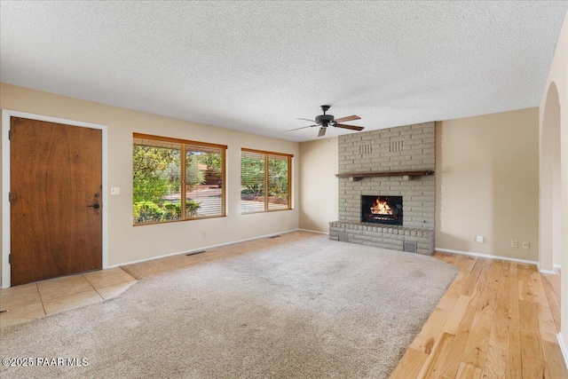 416 Hillcrest Dr, Prescott, AZ 86303 - unfurnished living room featuring a ceiling fan, a fireplace, a textured ceiling, baseboards, and wood finished floors
