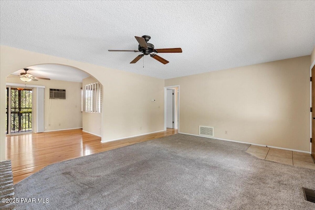 416 Hillcrest Dr, Prescott, AZ 86303 - carpeted empty room with ceiling fan, arched walkways, a textured ceiling, baseboards, and a wall mounted AC