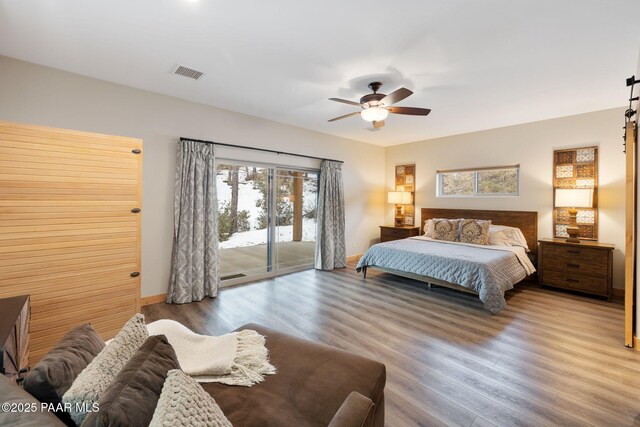 1700 S Sheriffs Posse Trl, Prescott, AZ 86303 - bedroom featuring visible vents, a ceiling fan, access to outside, wood finished floors, and a barn door