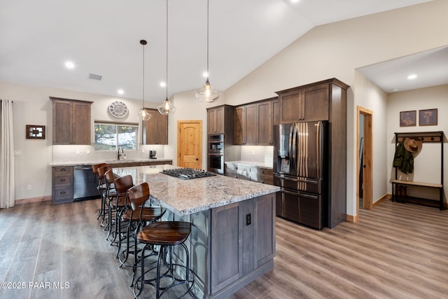 kitchen with sink, a center island, pendant lighting, stainless steel appliances, and decorative backsplash