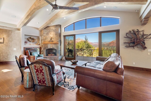 living room featuring a fireplace, beam ceiling, hardwood / wood-style flooring, and a mountain view