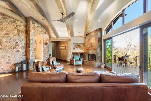 living room featuring vaulted ceiling with beams, ceiling fan, a fireplace, and wood-type flooring