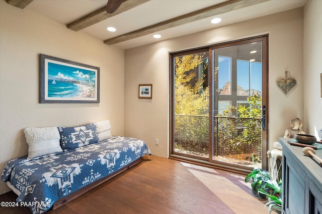 bedroom featuring beamed ceiling and wood-type flooring