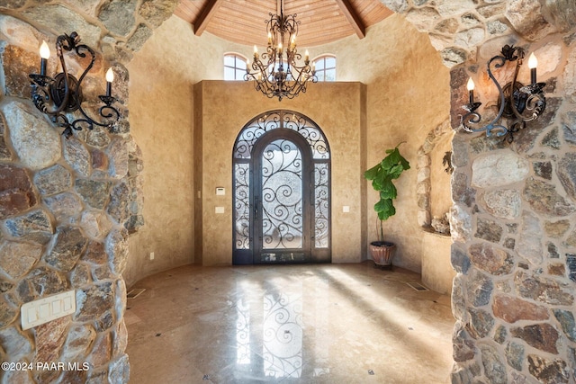 entryway featuring beamed ceiling, a high ceiling, wooden ceiling, and a notable chandelier