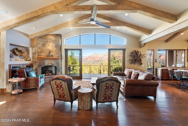 living room featuring beam ceiling, ceiling fan, dark wood-type flooring, a stone fireplace, and high vaulted ceiling