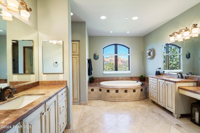 bathroom featuring tile patterned floors, vanity, and tiled bath