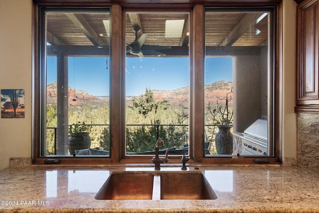 interior space featuring a mountain view, light stone counters, and sink