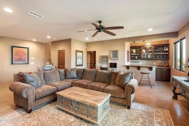 living room with bar area and ceiling fan