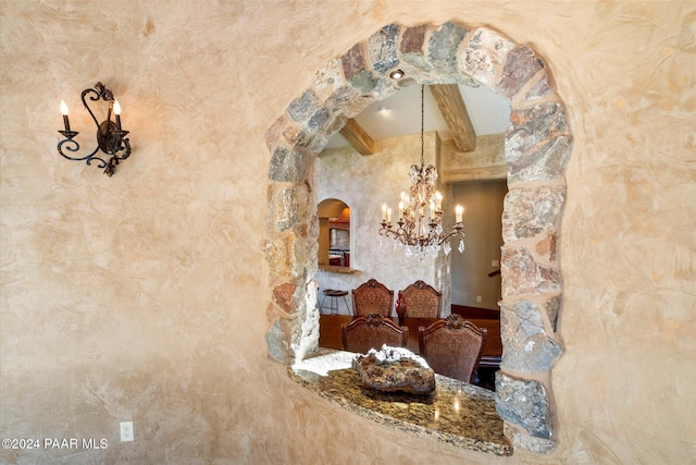 dining room with beam ceiling and a notable chandelier