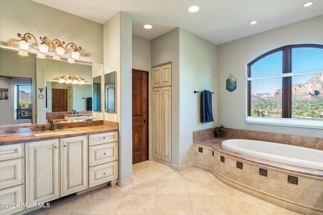 bathroom featuring tile patterned floors, vanity, and tiled tub