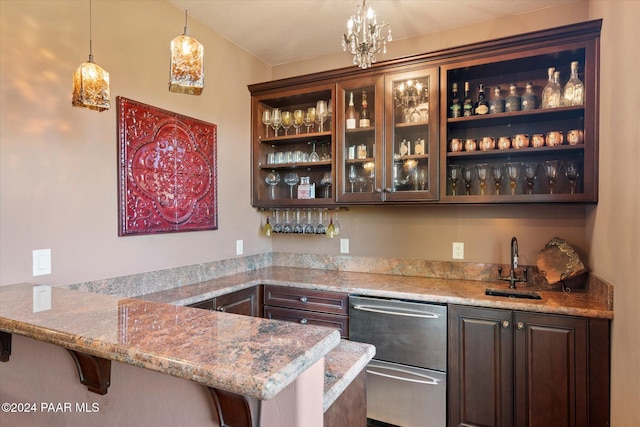 bar with light stone countertops, dark brown cabinets, sink, decorative light fixtures, and an inviting chandelier