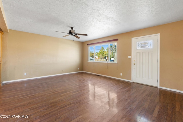 interior space with ceiling fan, dark wood-type flooring, and a textured ceiling