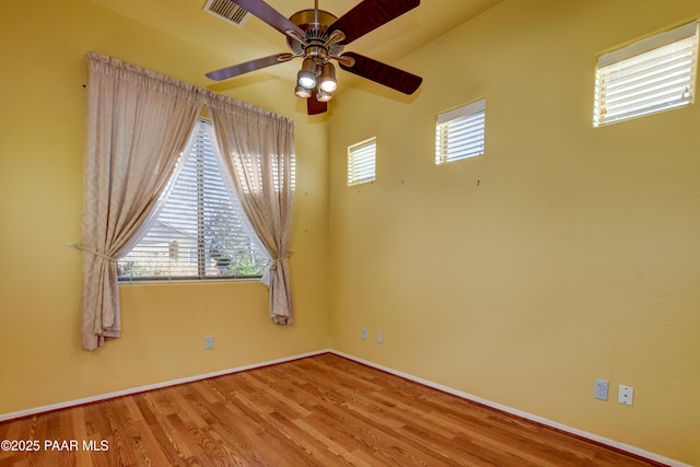 empty room featuring ceiling fan, plenty of natural light, and light wood-type flooring